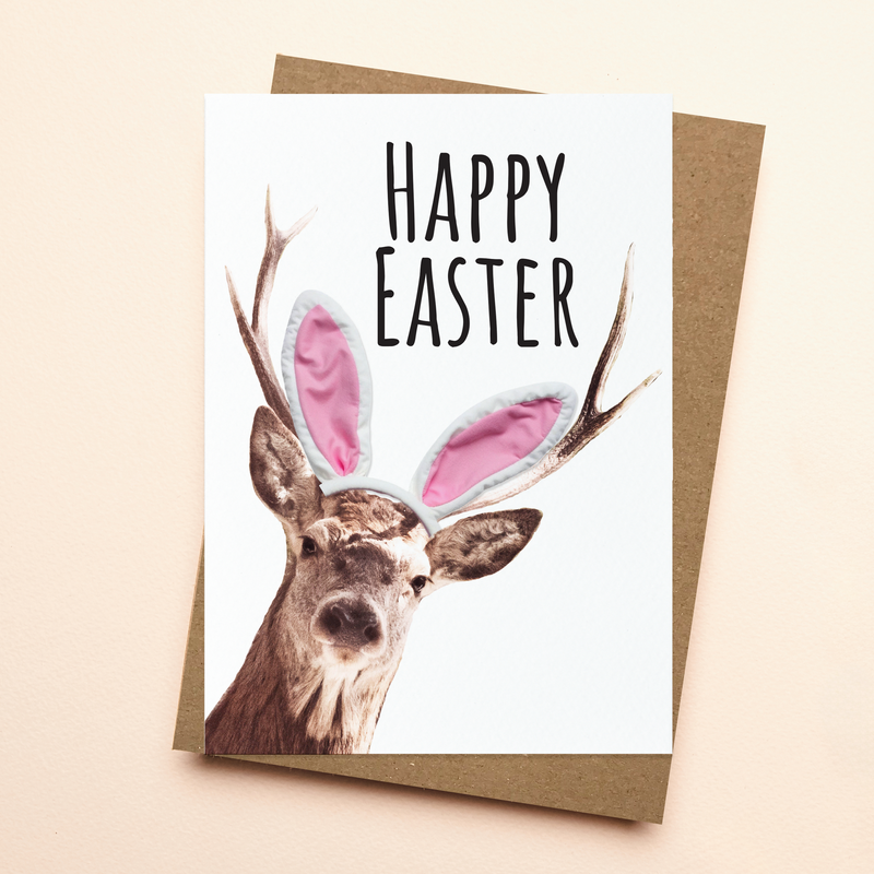 Easter card with a deer wearing bunny ears and 'Happy Easter' text on a beige background