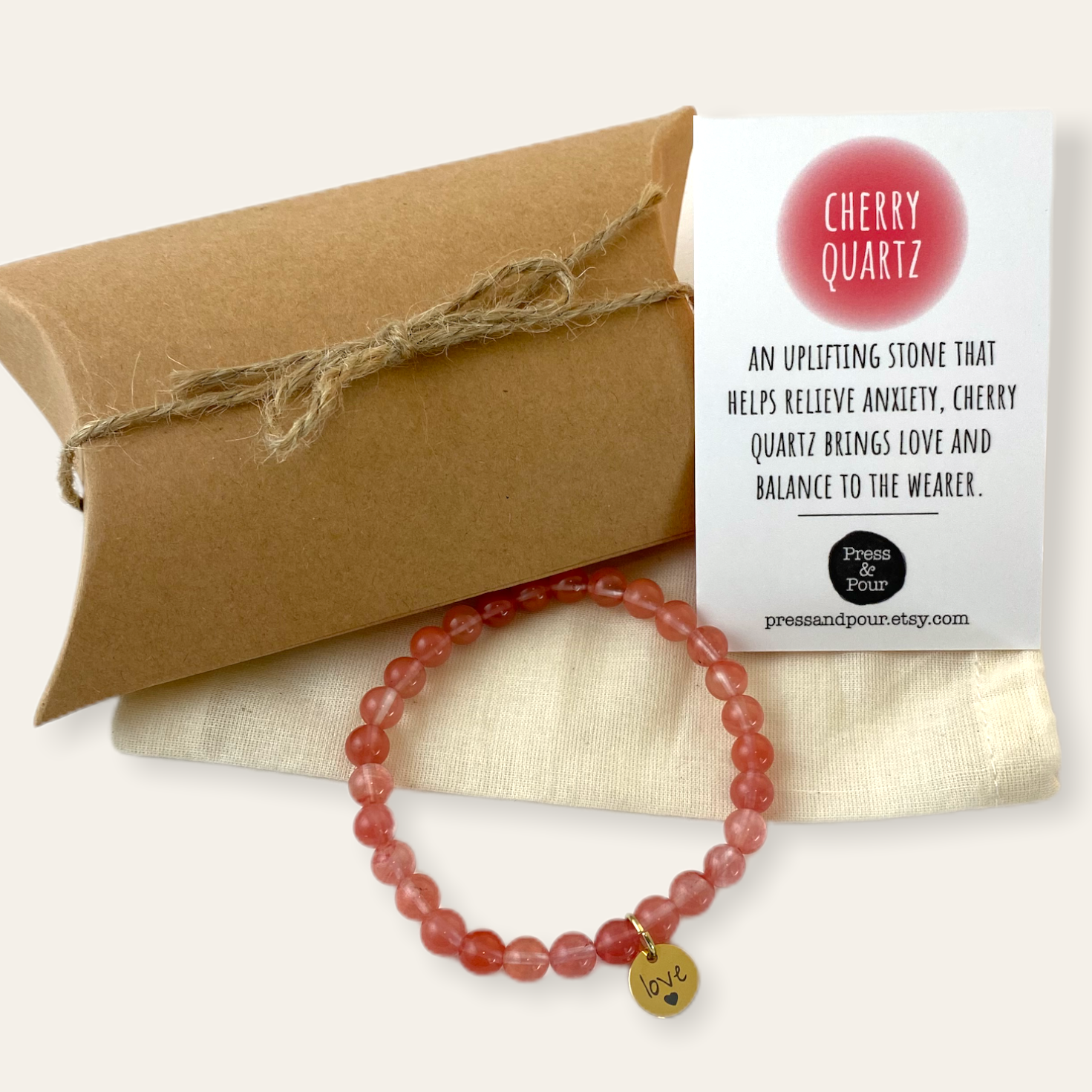 Cherry quartz bracelet with packaging and label on a beige background