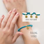 Two hands wearing turquoise bracelets with healing stones on a light background