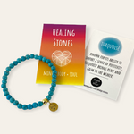Turquoise beaded bracelet with a gold charm on a white background, accompanied by a card about healing stones.