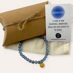 Blue beaded bracelet with a card on a beige background